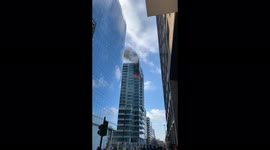 Aldgate (London) skyscraper on fire. Glass panels fall 100s of feet to the ground. Firefighters attempt to contain in.