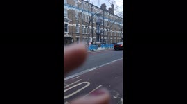 Woman walking on the streets of London holding an 'It's not easy being a princess sign'