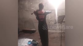 Violinist plays for displaced locals in bomb shelter