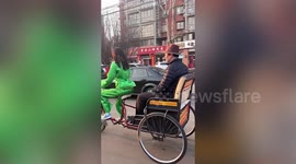 Chinese man kicks back in electric three-wheeler 'driven' by a robot