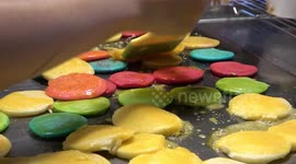 Delicious rainbow-coloured mini pancakes made at street food stall in Bangkok