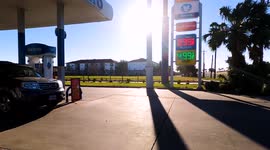 A vehicle sits at a gas pump near digital sign with gas prices in Corpus Christi, Texas