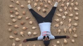Girl in South India smashes 106 coconuts laid beside her brave sister, while blindfolded, in 2 minutes