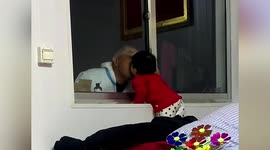 Elderly COVID-19 volunteer kisses granddaughter through glass window in China