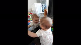 baby finds a friend in the mirror