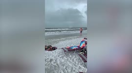 Beachgoers run for cover as waterspout turns into TORNADO at Florida beach resort