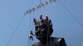 Abseiling workers descend onto Buddhist statue to clean monk's giant bald head