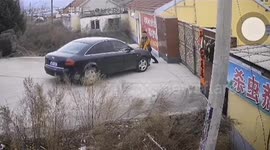 Man holds car to stop it rolling down road after he forgot to pull handbrake in China