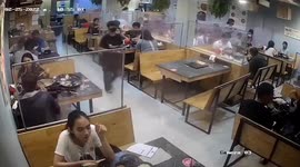Waiter slips and drops plates in busy restaurant