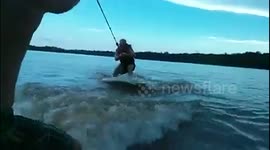 Man wake surfs without rope behind a boat... catches a beer