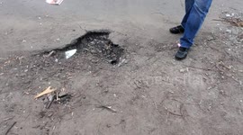 Crater from Russian shelling at Residential complex in Kyiv; damaged apartments