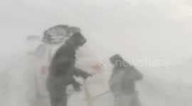 Police officers rescue vehicles trapped on snow-covered road due to blizzard in China