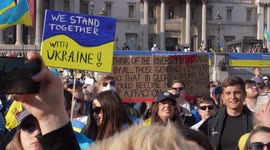 People with placard in crowd at London Stands with Ukraine: March and Vigil in Trafalgar Square