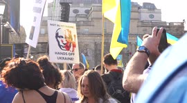 Placard of Putin being held by people at the London Stands with Ukraine: March and Vigil