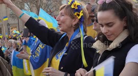 Woman dressed in Ukraine colours chanting at London Stands with Ukraine: March and Vigil