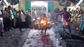 Devotees carry rings of fire as they walk barefoot across burning charcoal in southern India