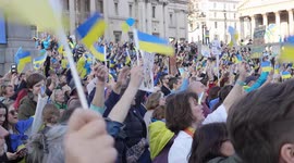 People waving Ukraine flags at the London Stands with Ukraine: March and Vigil