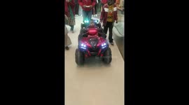Enjoying baby with family members on remote control car in mall