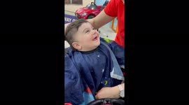 Adorable baby can't stop smiling while getting is hair cut