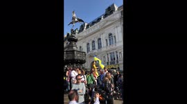 Ukrainian protest March in london , woman waving Ukrainian flag and Piccadilly lights showing the words” Imagine Peace”