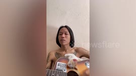 Kitten falls asleep while owner plays the guitar