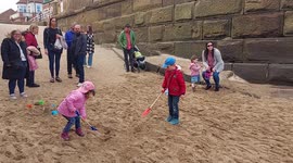 Kids playing on the Whitby, harbour beach North Yorkshire, England, UK