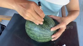 Vietnamese man sculpting a beautiful 3D heart on top of the watermelon