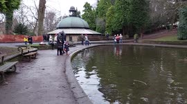 Kids at the boating lake racing boats in Valley Gardens Harrogate North Yorkshire UK