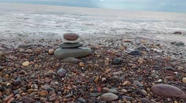 Tower made of flat stones with calming waves in the background Seaside Saltburn by the sea UK