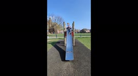 A boy and a girl going down a slide together on a sunny day in York North Yorkshire
