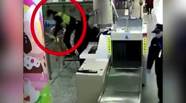 Police officer tends to elderly woman who fell down stairs at train station in China
