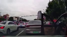 Motorist cuts into lane using his open door to block cars in China