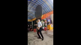 The man uses his mouth to balance the tables on high