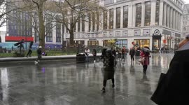 Londoners scurry from heavy showers splashing West End