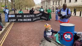 Climate activists dressed as doctors block street outside the Treasury in Westminster