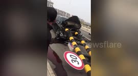Height restriction barrier impales car after sanitation truck knocks it down in China