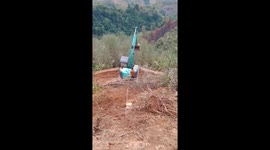 The excavator driver moves on a cliff tens of meters deep