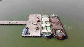 Cargo ships bound for Myanmar load on docks in southern Thailand