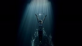 Freediver dives through bubble ring in underwater cave