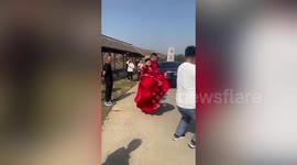 Chinese bride protects husband with stick during playful wedding tradition