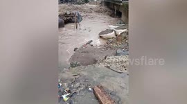 Frantic residents watch as raging river is inches away from reaching homes in the Philippines