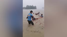 Officers pull flooded locals to safety during Tropical Storm Megi in the Philippines