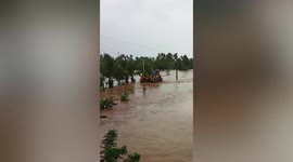 Rescuers carry locals to safety in digger as Tropical Storm Megi hits central Philippines