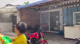 Children spray water guns at start of Songkran new year festival in Thailand