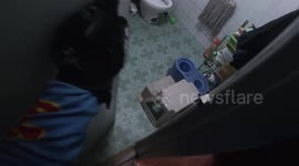 FPV of snake wrangler catching reptile in family's bathroom