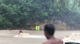 Motorcycle rider trying to cross flooded bridge swept away before being rescued