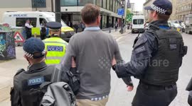 Police officers arrest Extinction Rebellion activist during protest at Shell HQ in London