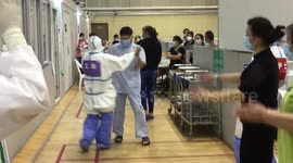 Chinese medical staff dances with patient at makeshift hospital during Shanghai lockdown