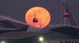 Amazing Pink Moon rises behind Emirates cable car in London