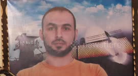 The mother of Palestinian Prisoner Ahmed al-Zahar, Kifah Abu Jayab, who is not allowed to visit him, displays his picture on the Palestinian Prisoner's Day